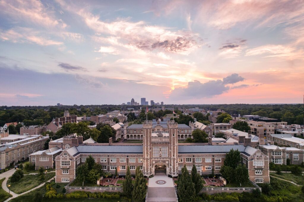 Drone footage of the Danforth campus buildings from above with a sunset sky in the background