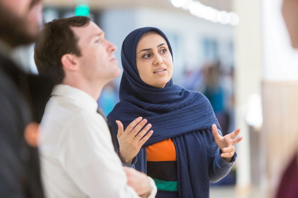 Researcher explains their project to an attendee of the George Warren Brown School of Social Work's Research Without Walls presentation