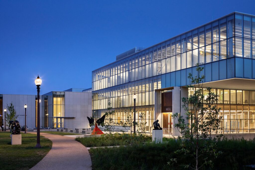 Weil Hall (right) and the expanded Mildred Lane Kemper Art Museum (left) pictured at night with lights glowing from within the buildings